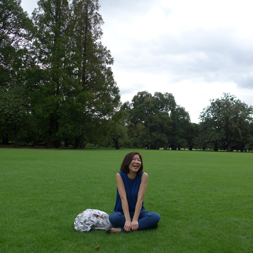 Image of a middle aged woman sitting on the ground smiling